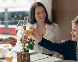 Eine Familie stößt mit Champagner und Orangensaft zum Frühstück an.