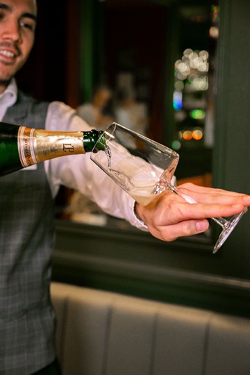 Ein Kellner schenkt Champagner in ein Glas ein, um eine elegante Verkostung zu beginnen.