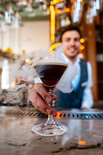 The art of cocktail making A cocktail is served with smoke in a glass.