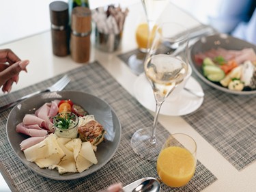 Ein Frühstücksteller mit Schinken, Käse, Gemüse und einem Glas Orangensaft.