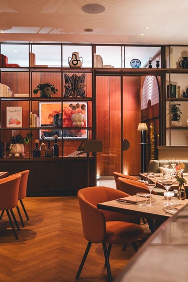 Ein eleganter Blick auf den stilvollen Restaurantbereich im Restaurant Veranda, mit einem offenen Regal und modernem Mobiliar.