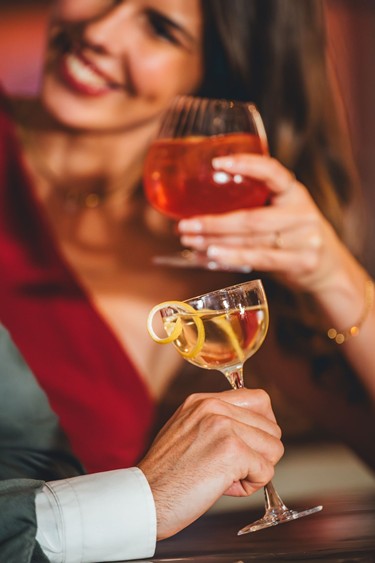 Zwei Personen stoßen mit Cocktails an.