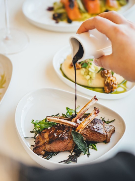 Zartes Lammkarree mit Kräutern und Jus kunstvoll angerichtet in der Veranda Brasserie & Bar.