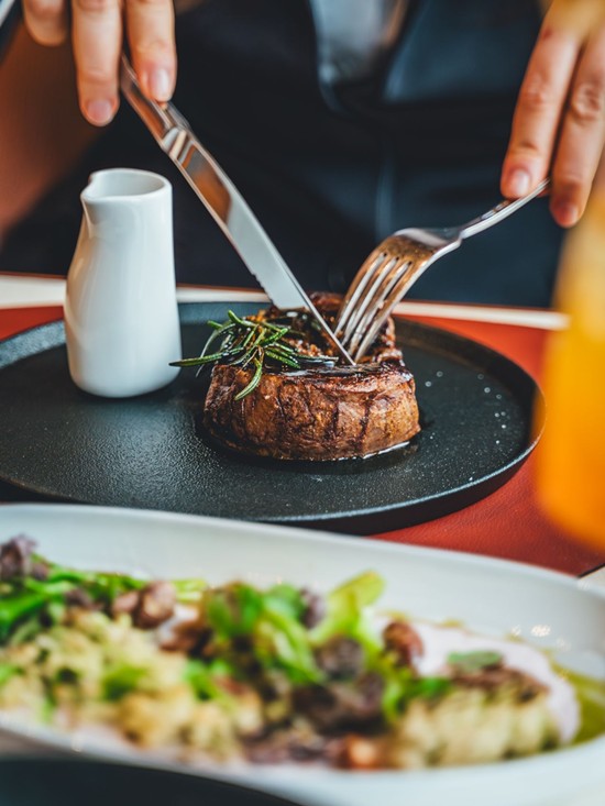 Saftiges Steak mit Rosmarin und Jus stilvoll angerichtet in der Veranda Brasserie & Bar.